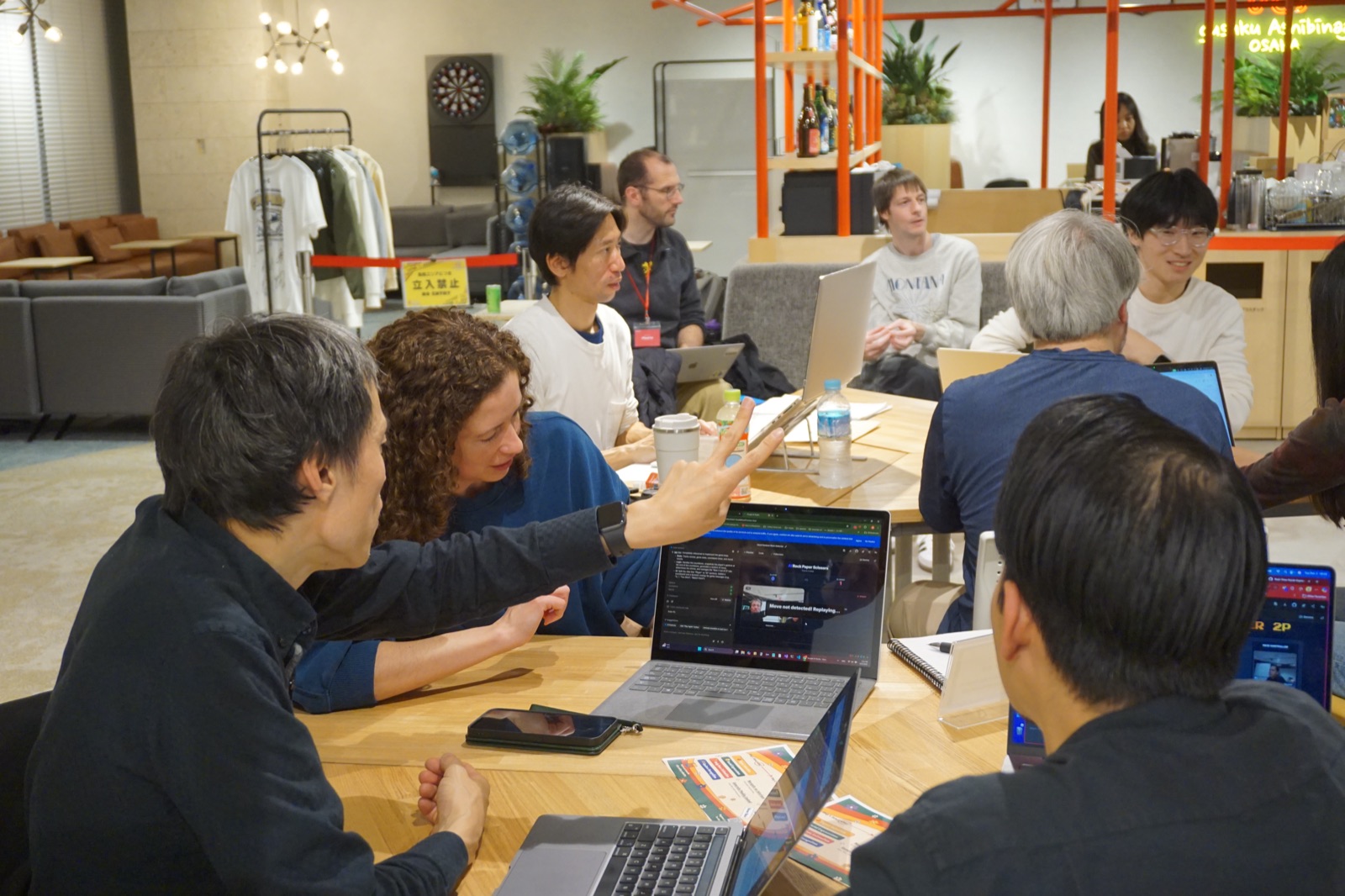 Vibe Coding Collective members reviewing a project together on laptops